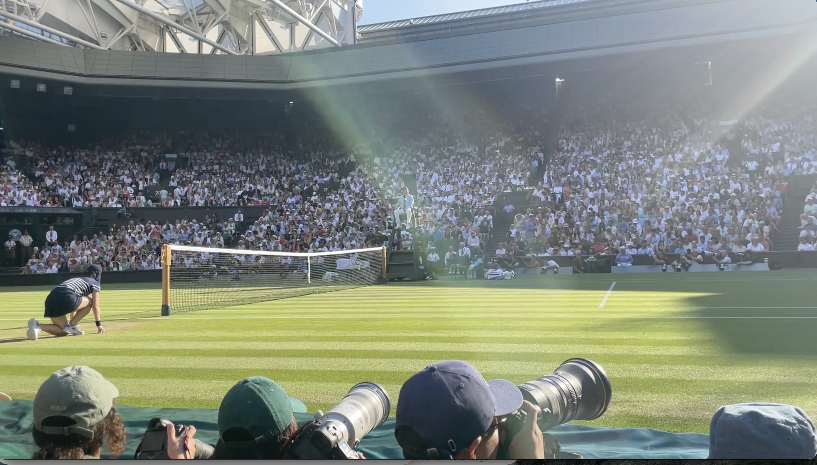 Tennis match taking place on a grass court at Wimbledon.